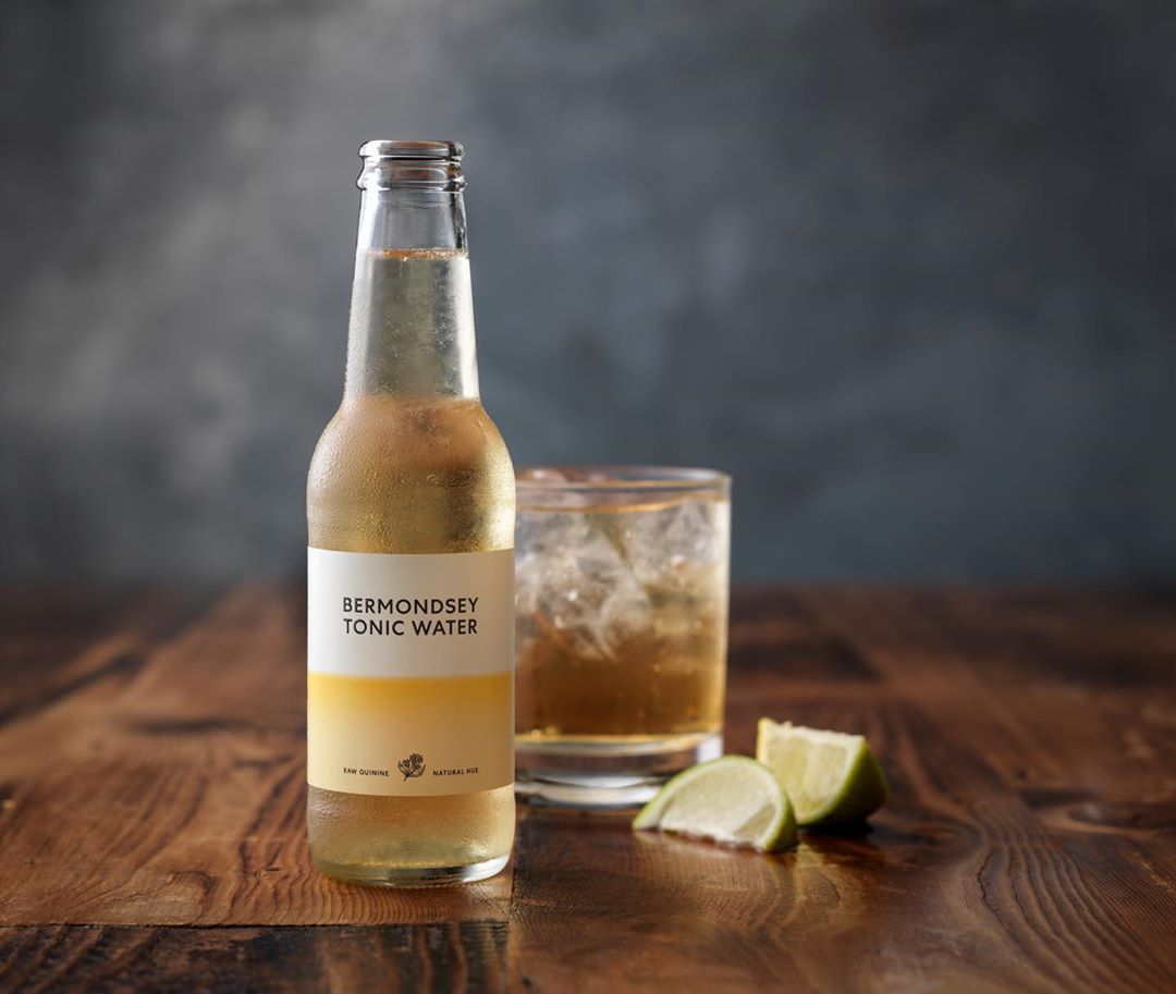 Flaske Bermondsey tonic på et bord med et glas og lime skiver
