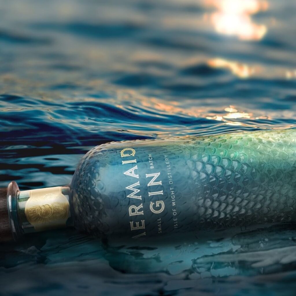 Flaske Mermaid gin, der ligger i havet.